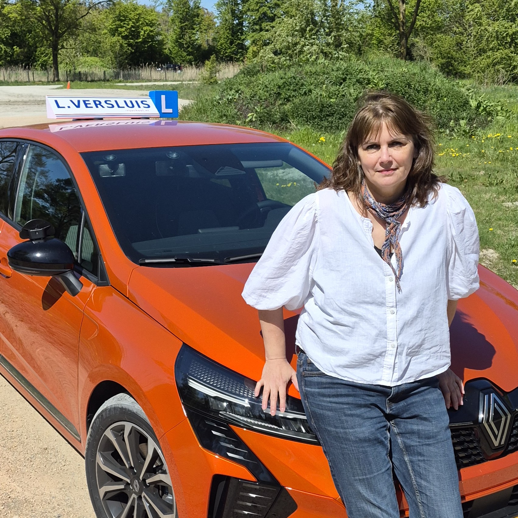 L. Versluis — rijinstructeur bij de oranje lesauto